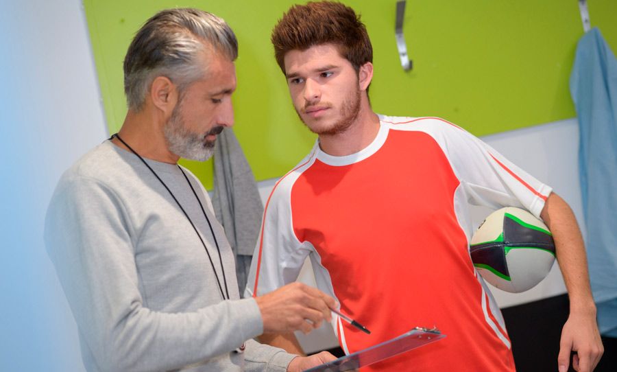 Hombre asesorando futbolista